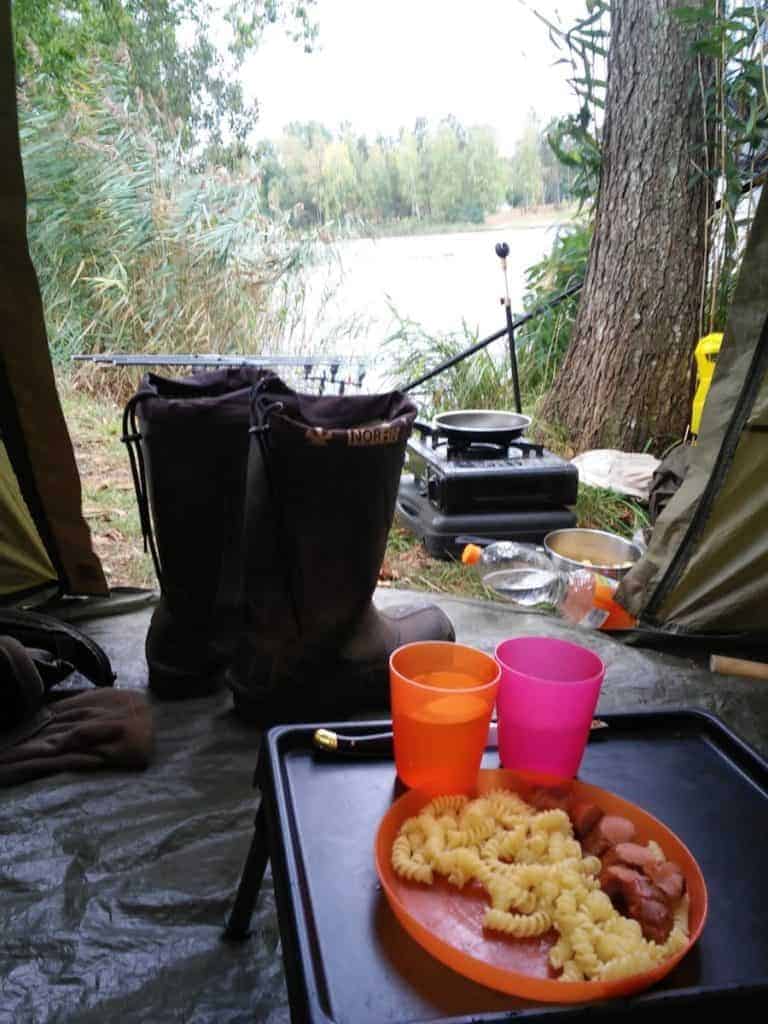 a plate with pasta and meatballs in a tent on a fishing trip