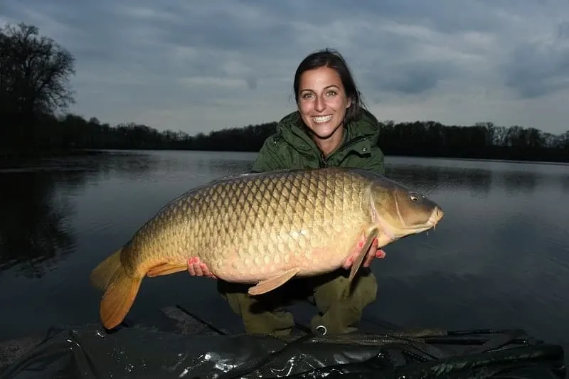 claudia darga on a lake holding a big common carp