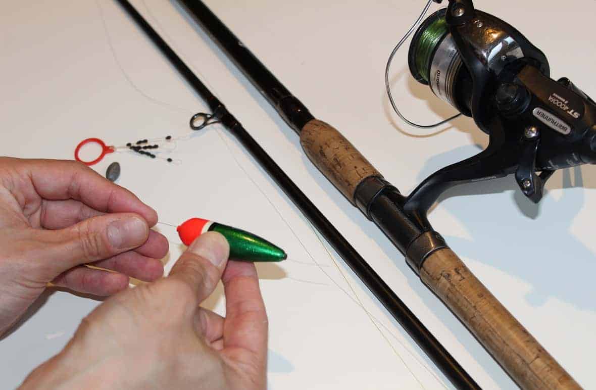 an angler putting a slip bobber on the fishing line