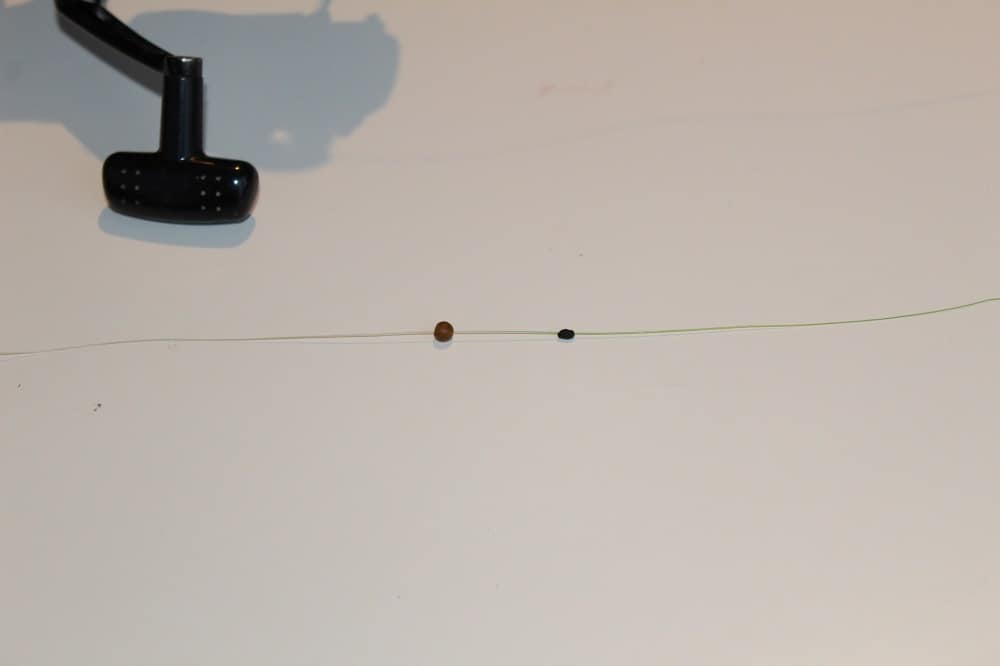 an image of a piece of fishing line with a bobber stop and a stop bead on it