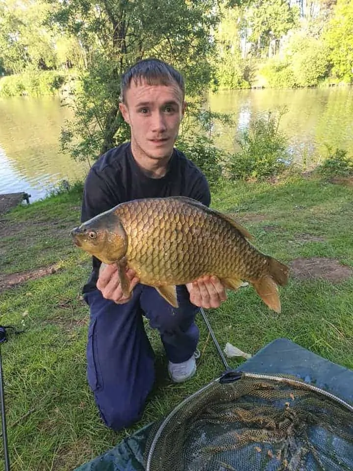 a British angler on a fishery holding a really big F1 type carp