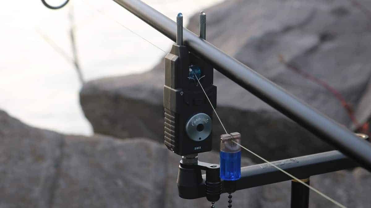 an electric bite alarm with snag ears and a hanger mounted on a rod pod
