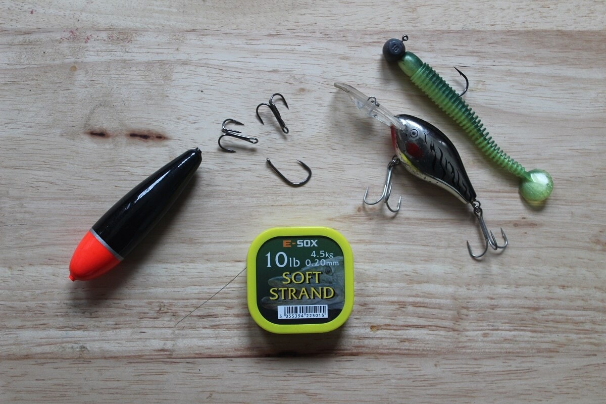 perch tackle, float, hooks, trebles, softbaits, crankbaits, and soft wire trace displayed on a table.