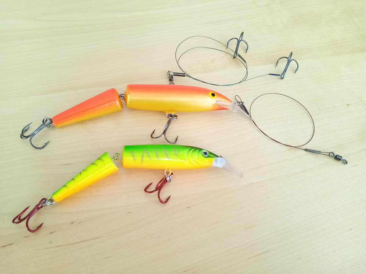 Two crankbaits and a couple of wire leaders for fishing displayed on a table