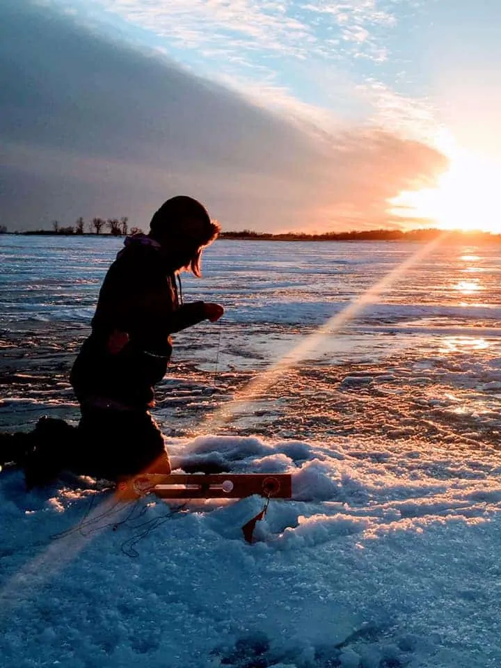 an ice angler preparing a tip-up for northern pike