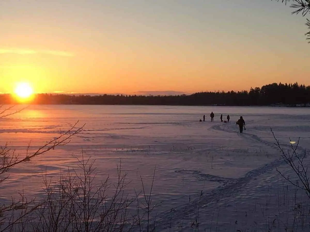 an image of a group of anglers ice fishing on a frozen lake