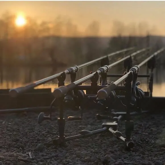 an image of a rod pod with three carp rods at sunrise