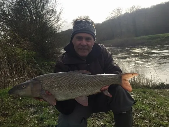 angler matt hayes on a river with a really big barbel