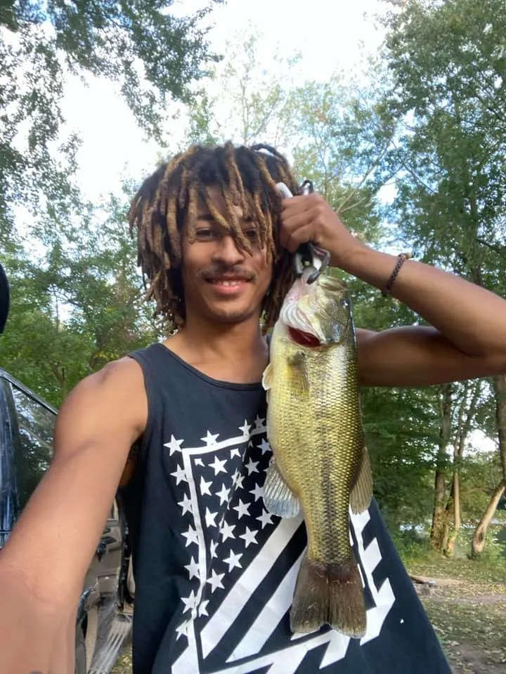 a happy bass angler holding a nice largemouth bass that he has caught on a small crankbait