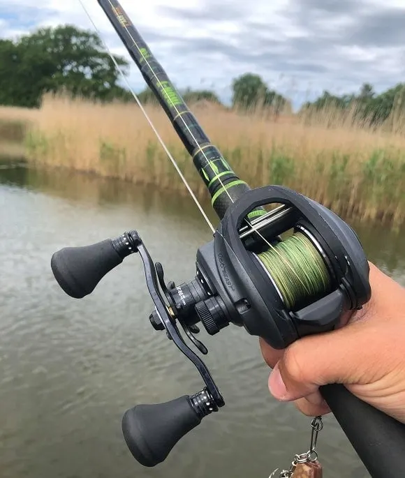 a predator angler holding a rod and a baitcaster spooled with power pro braid