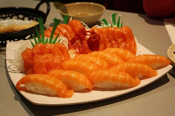 a plate full of salmon sushi pieces