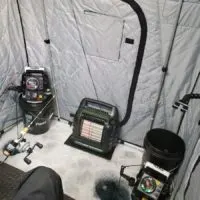 the inside of an ice fishing shack with a mr buddy heater and two portable fish finders