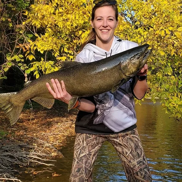 a female angler on Lake Michigan with a giant king salmon