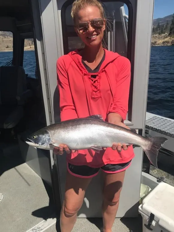 a female angler on a boat on Lake Roosevelt with a nice kokanee salmon