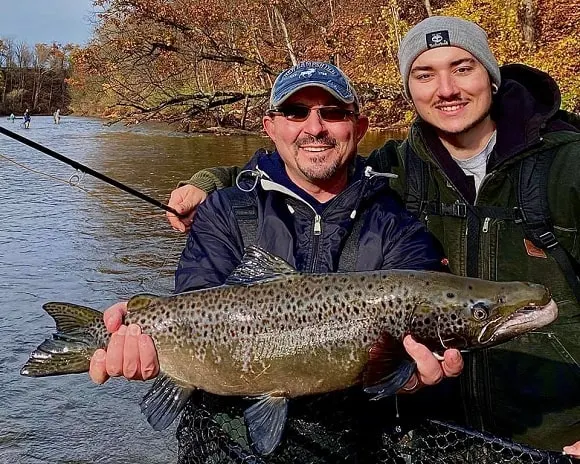 two fishermen on Lake Ontario with a beautiful brown-colored Atlantic salmon