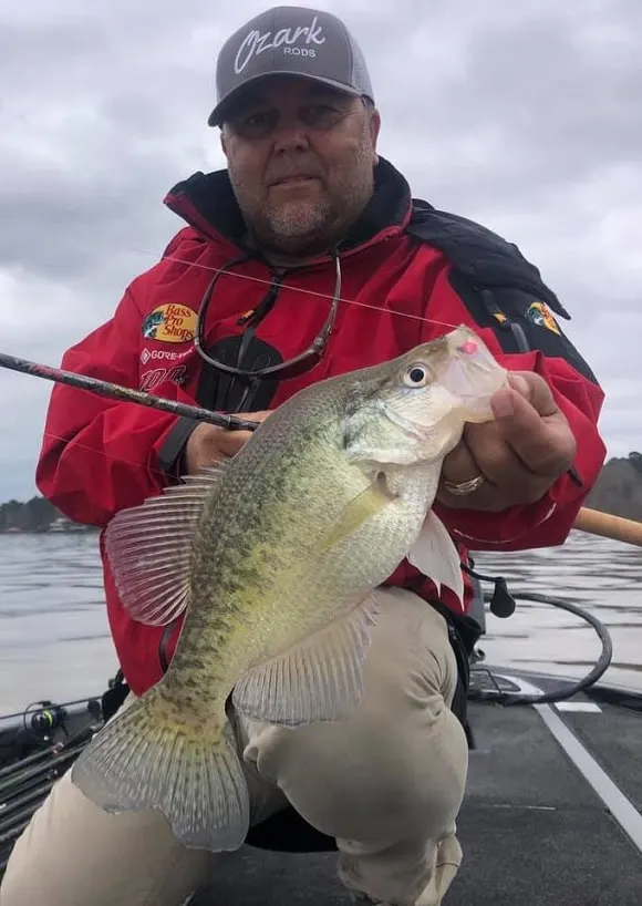 an angler on a lake with a nice crappie caught on a jig