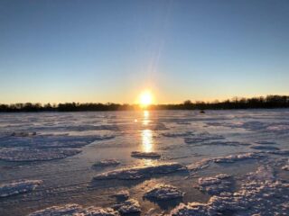 a beautiful morning on a frozen lake nipissing with a rising sun