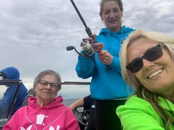 a group of female anglers on a boat fishing with plfueger spinning reels