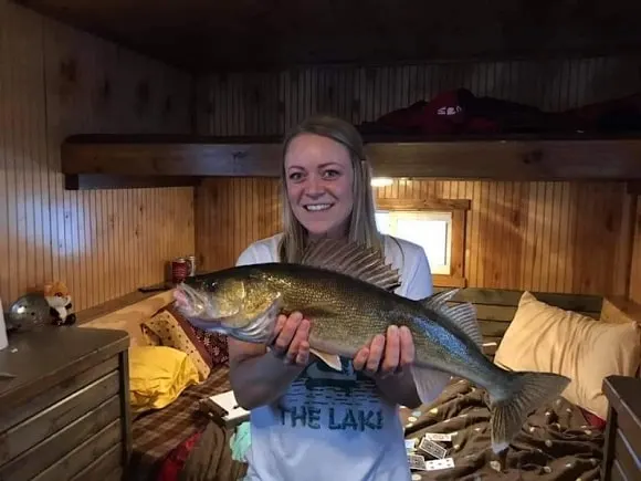 a female angler in an ice house with a big Leech Lake walleye