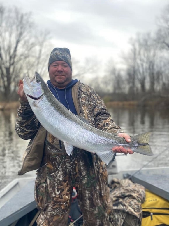 a trout angler with a long steelhead caught in 40F water