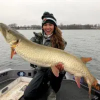 Nattie up North on her boat holding a giant Minnesota musky