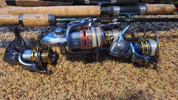 an image of three plfueger spinning reels on a carpet