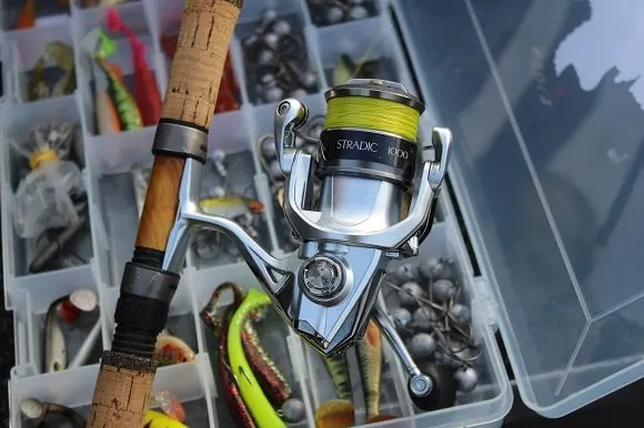 a shimano stradic in front of a tackle box