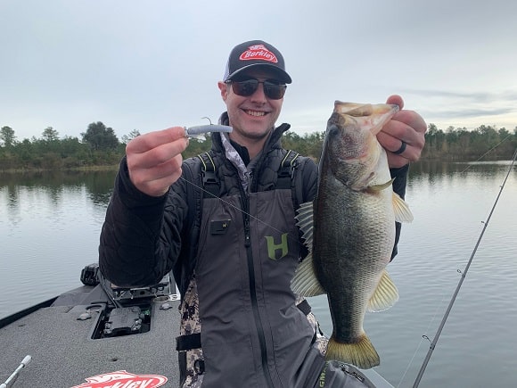 a pro staffer with a big largemouth bass caught in the shallows