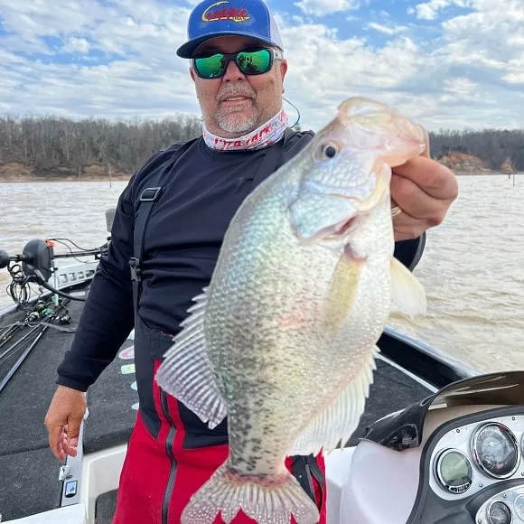 a fisher on his boat with a really big white crappie