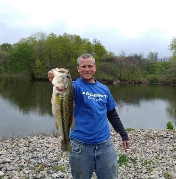 an angler at a lake with an average sized largemouth bass