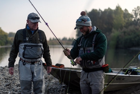 two fly fishermen ending a fishing trip on a river