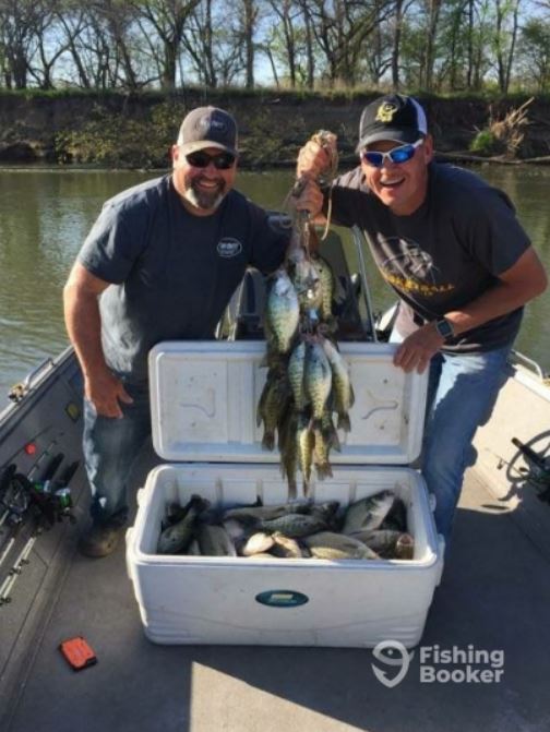 two anglers on a boat with several nicely sized crappie