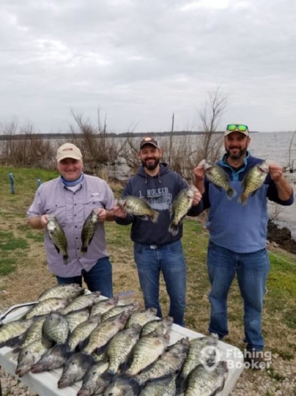 a group of happy anglers with a filled bag limit of crappie in texas