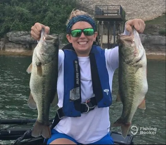 a happy angler on a boat with two big Texas largemouth bass