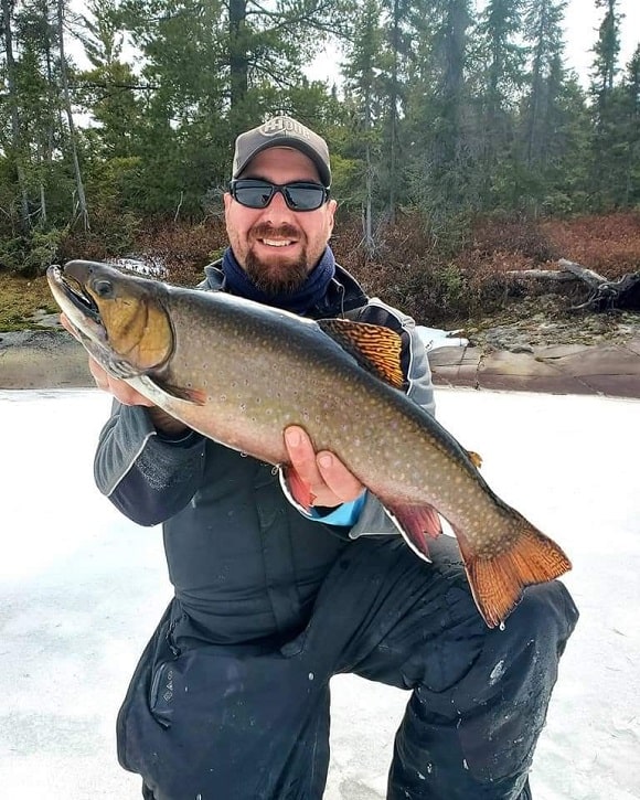 a canadian ice angler with a huge lake dwelling brook trout