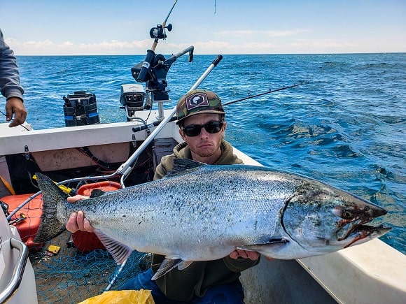a salmon angler on Lake Michigan holding a big king salmon