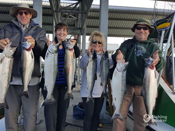 a group of fishing charter customers with a bunch of salmon from the puget sound