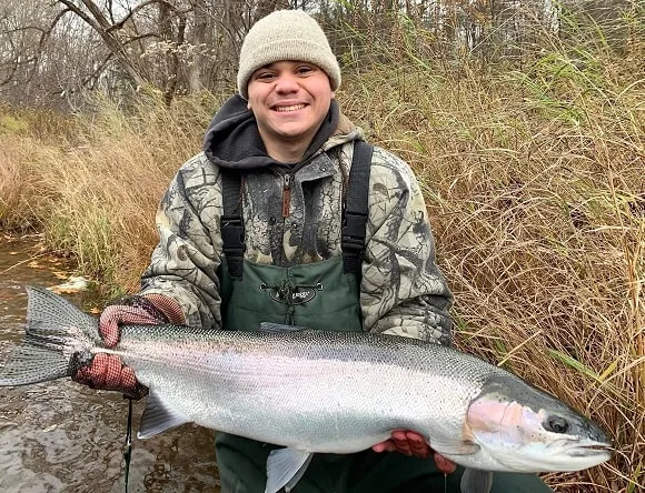 a trout fisher on the Salmon River with a huge steelhead