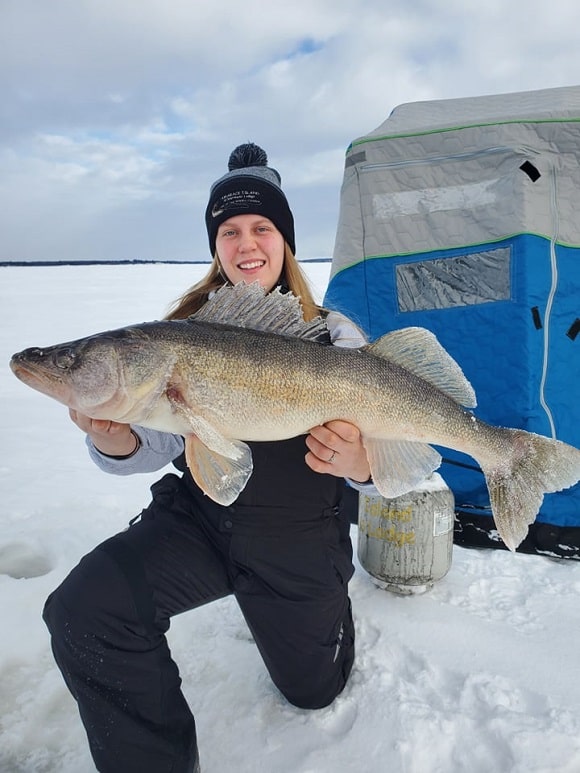 a female angler ice fishing walleye on lake of the woods