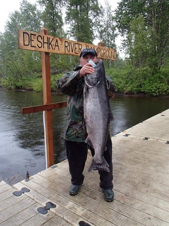 a happy angler with a big Alaska chinook salmon