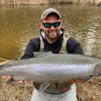 a happy Oregon trout angler with a huge steelhead