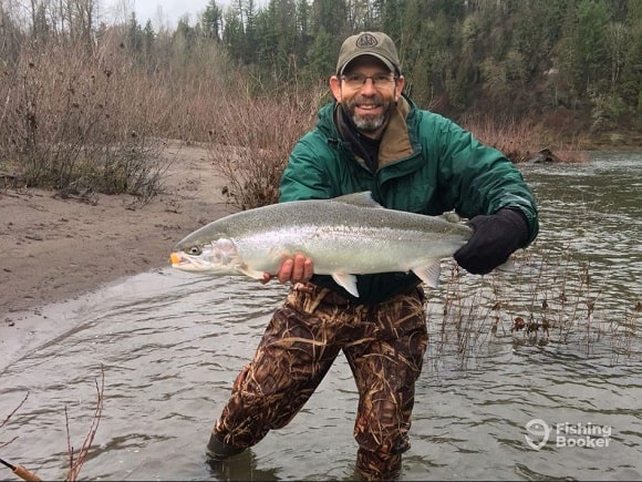 a fly fisherman with a big fall steelhead on the Sandy River