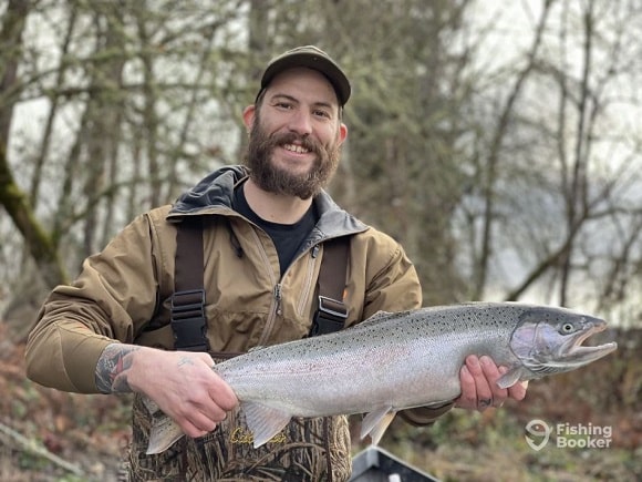 a happy angler holding a nice steelhead on the Columbia River