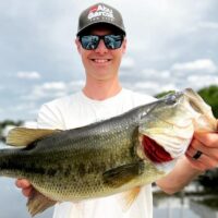 a Florida bass angler on his boat holding a huge largemouth bass