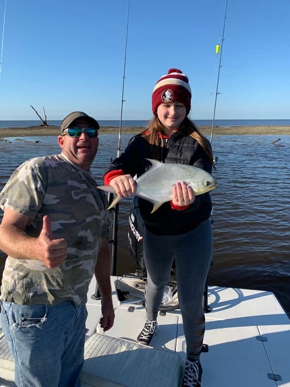a fishing dad and his daughter with an average sized florida pompano
