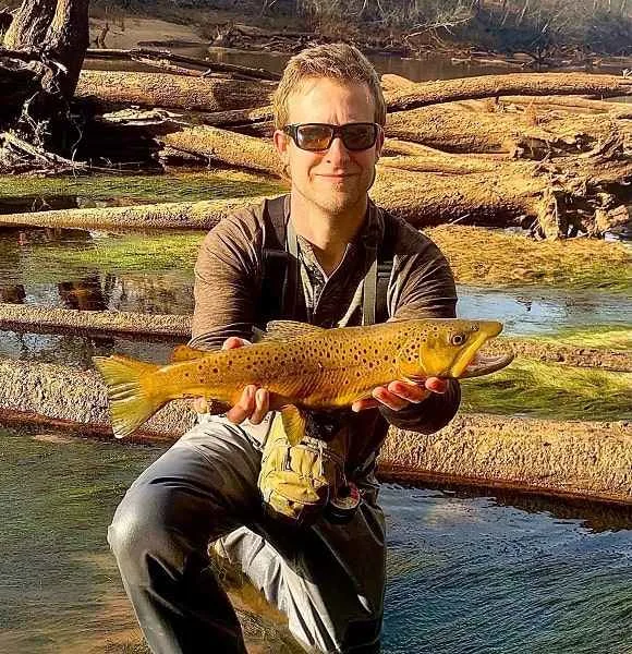 a happy Atlanta fly fisherman with a wild brown trout