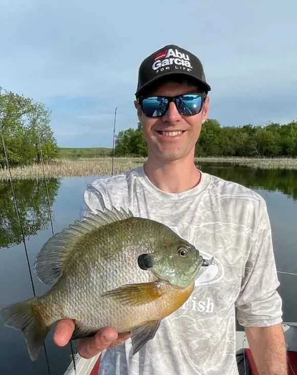 a happy angler holding a big bluegill caught on a crankbait