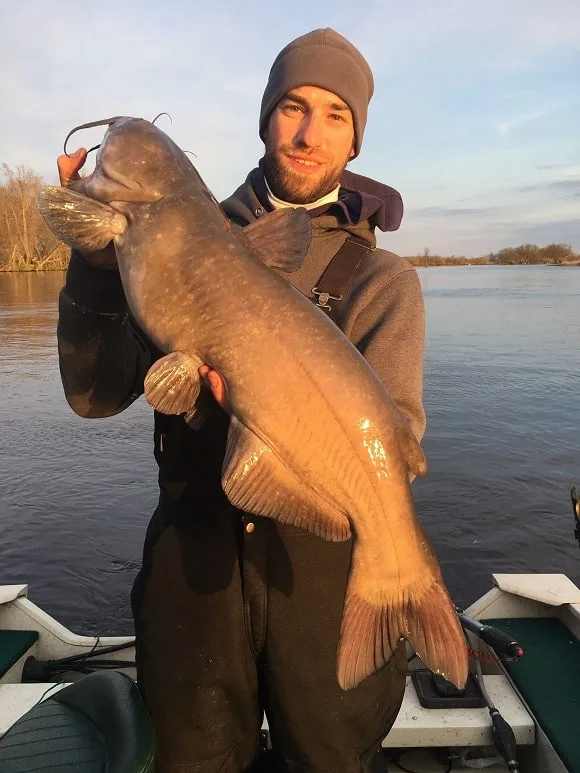 a happy angler holding a trophy-sized channel catfish