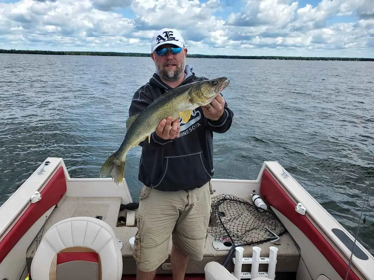 a US angler on his boat holding a nice walleye