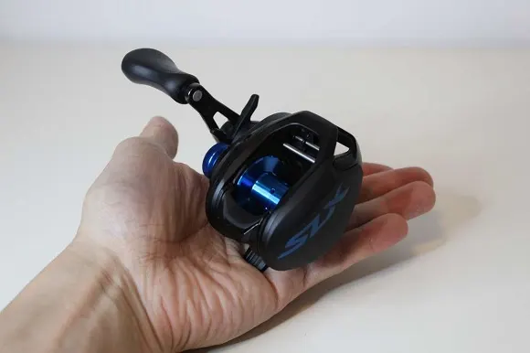an angler holding the compact Shimano SLX baitcaster in his hand